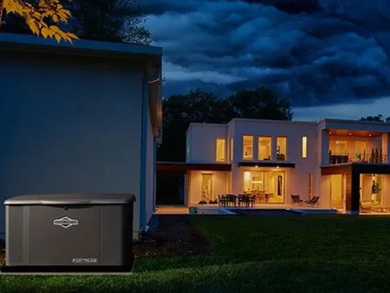 A sleek black power generator in a backyard at dusk, beside a modern home illuminated by warm lights.