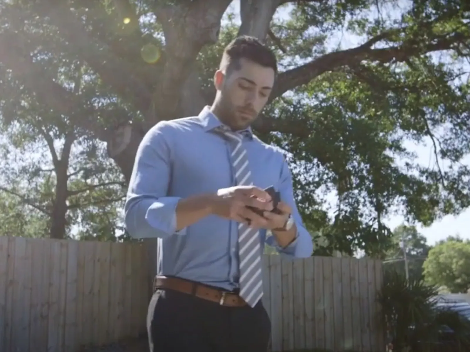 a man standing outside looking at his phone