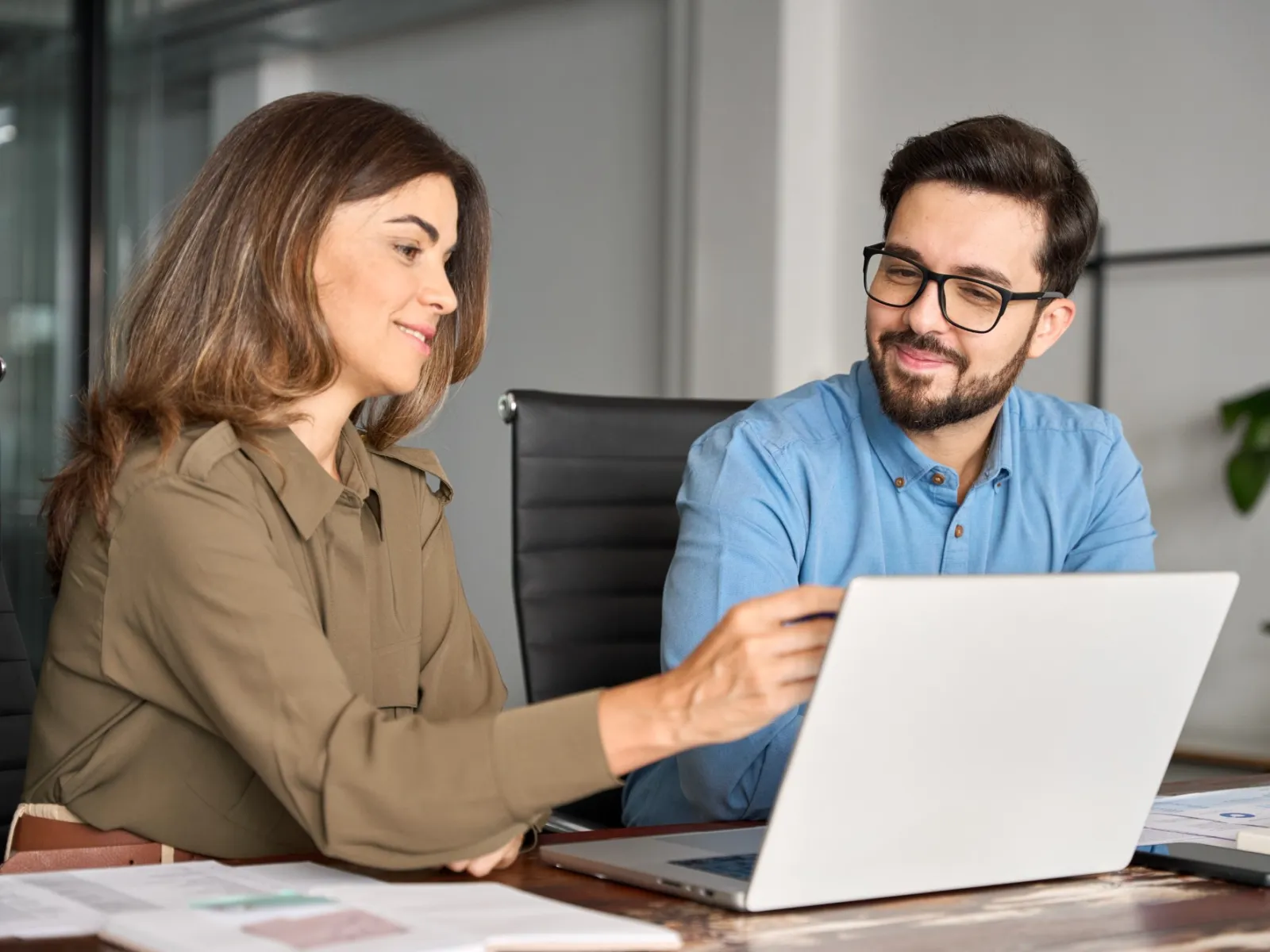 a man and a woman looking at a laptop