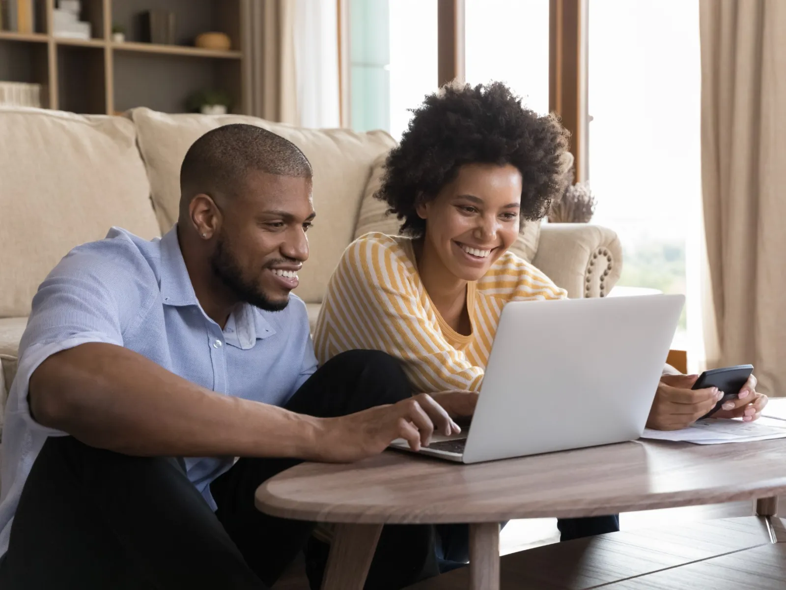 a man and a woman looking at a laptop