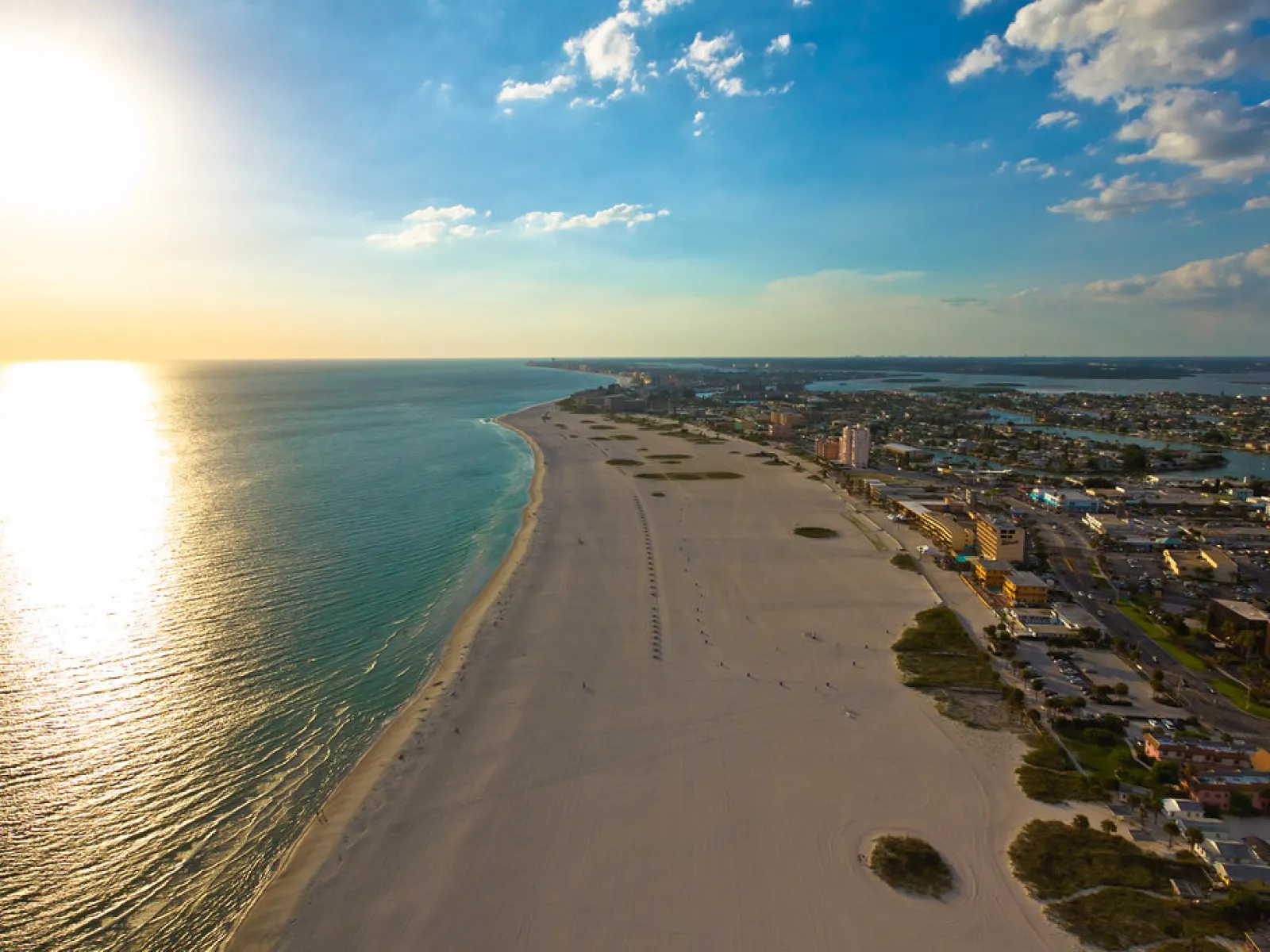 a beach with a body of water and buildings on the side
