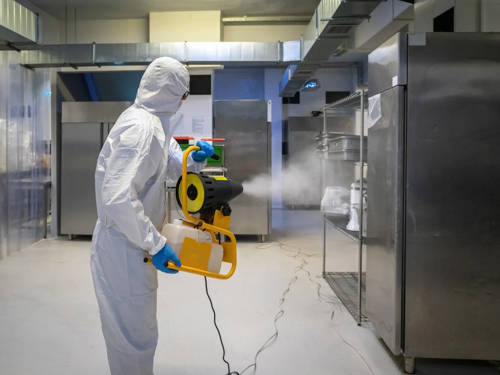 a man in a white lab coat working on a machine