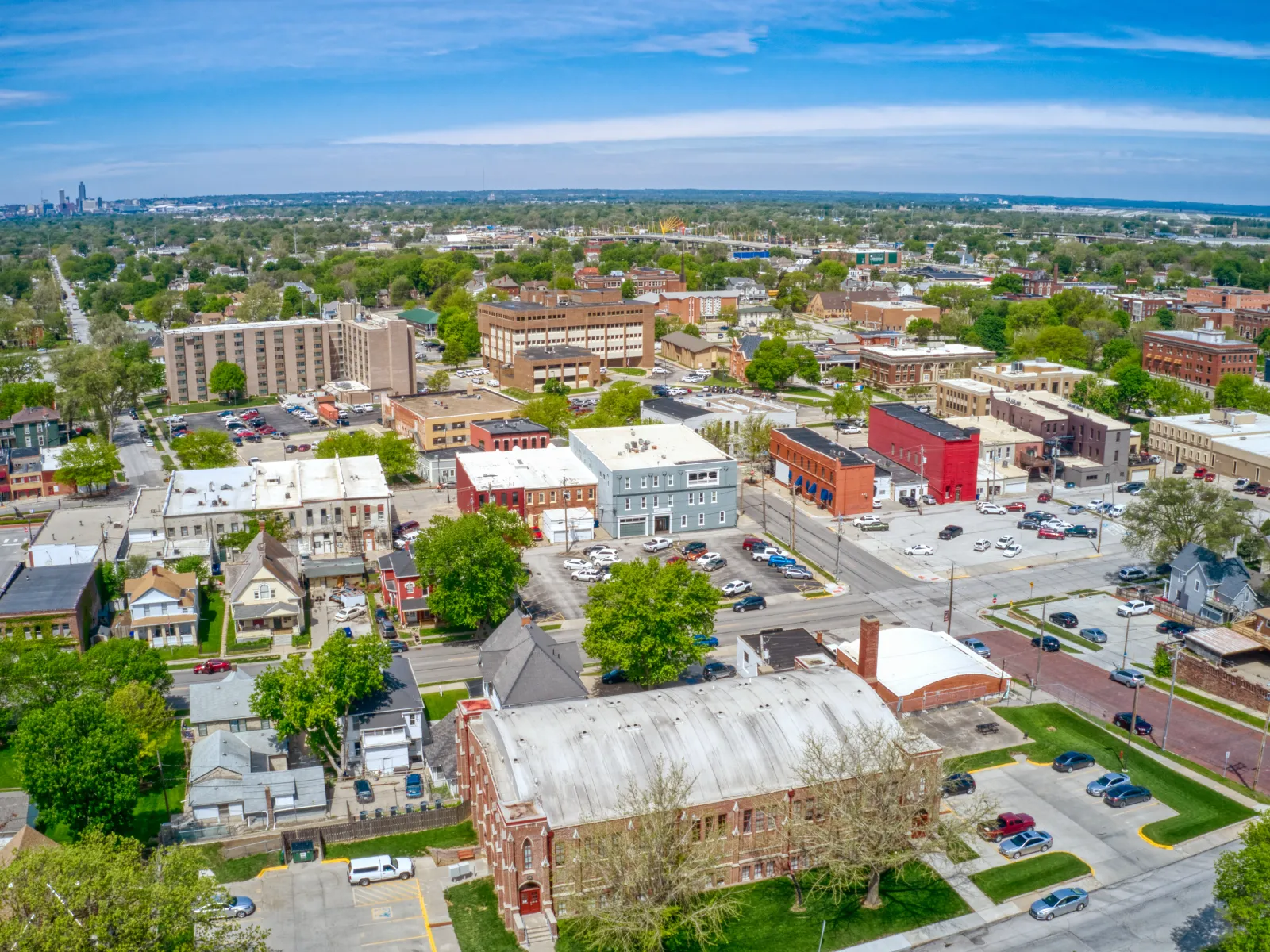Aerial view of a suburban neighborhood with residential and commercial buildings under a blue sky.