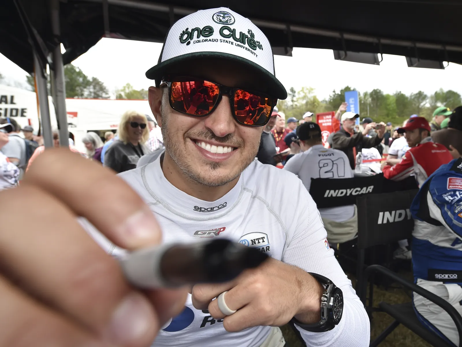 a close up of Graham Rahal holding a baseball bat