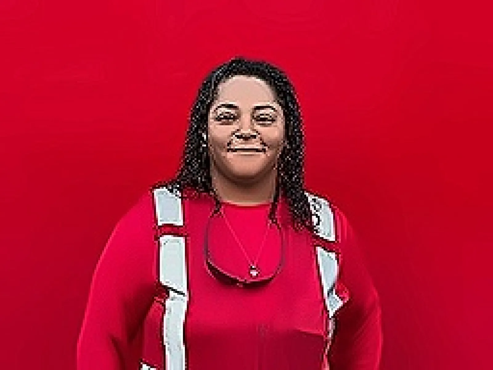 Portrait of a smiling woman in a red top with safety harness against a red background