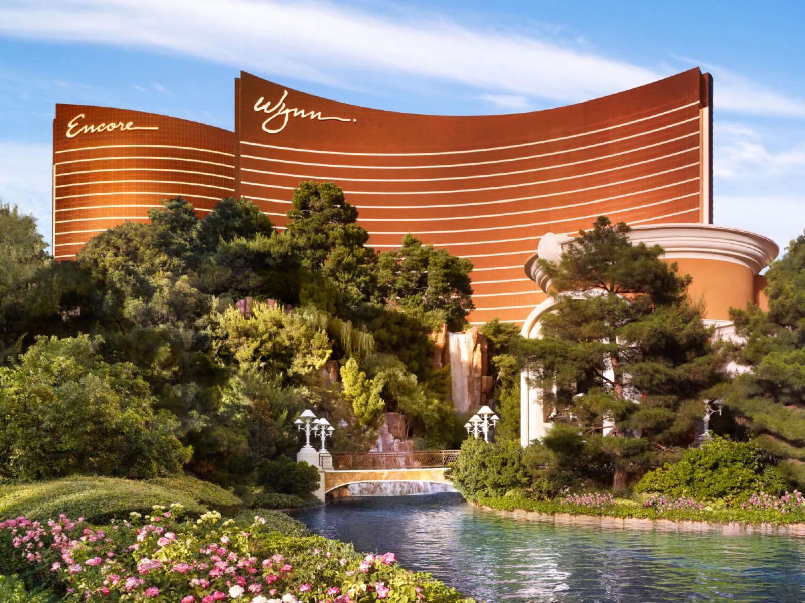 Wynn Encore resort in Las Vegas with lush gardens and a scenic pond.