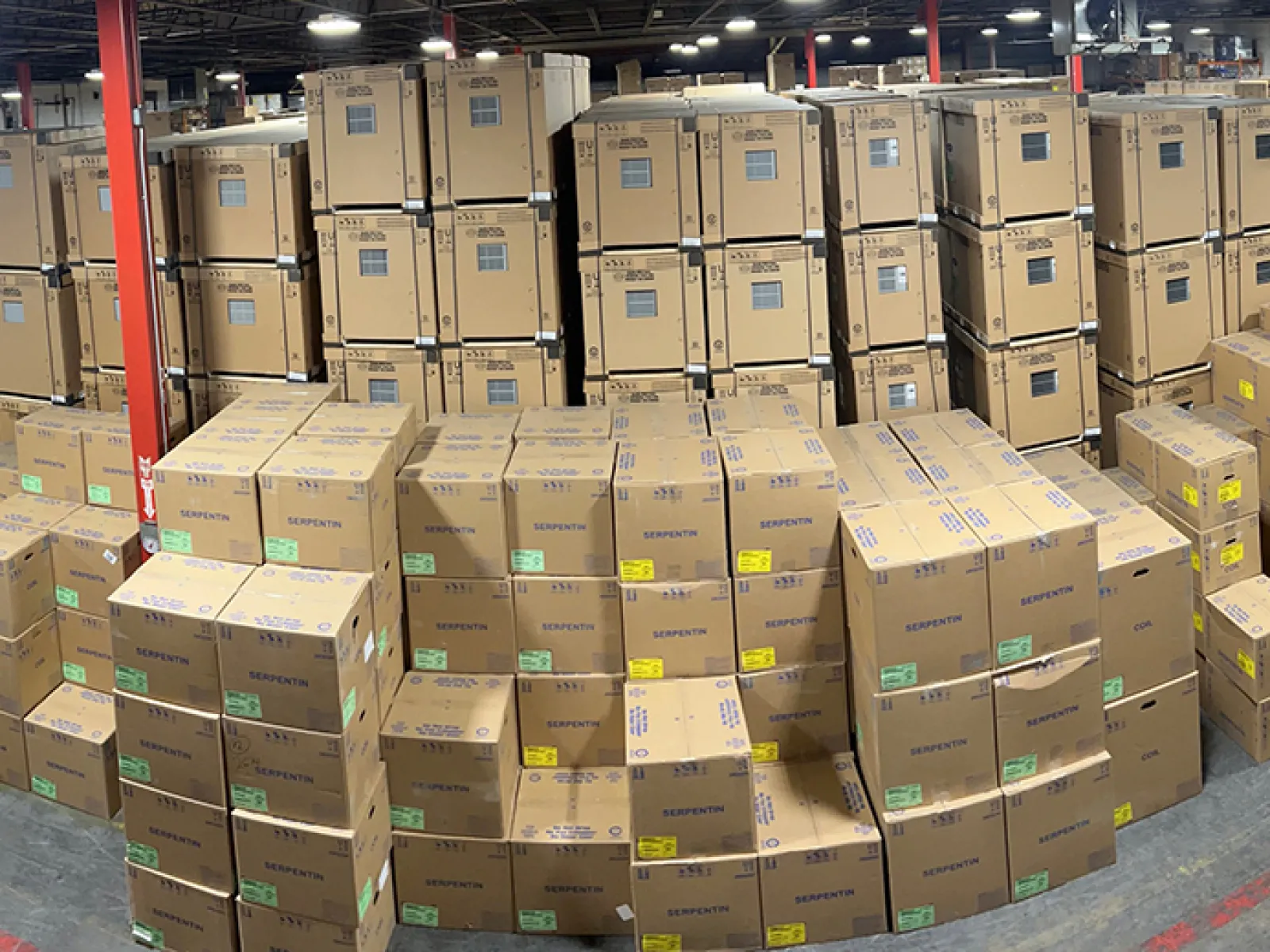 A spacious warehouse filled with stacked cardboard boxes and organized storage.