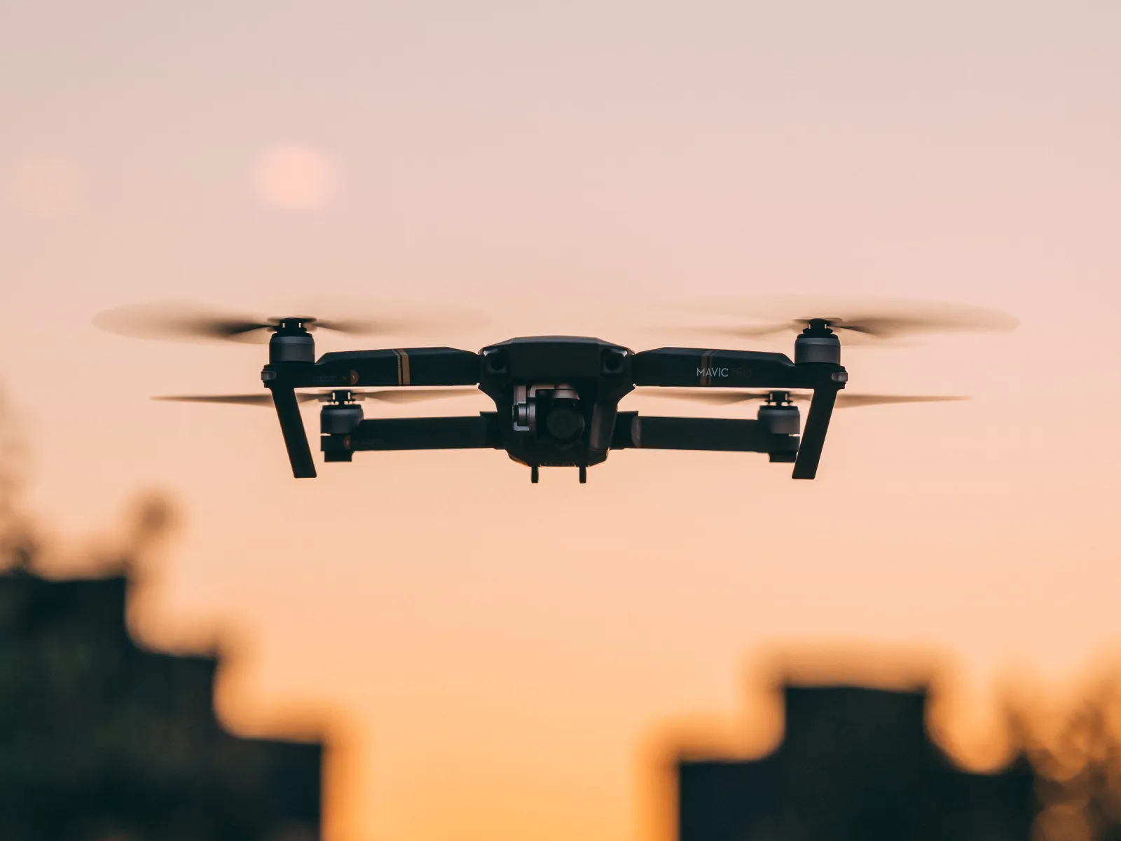 Person using calculator and analyzing financial documents at a desk with computer monitor showing data.
