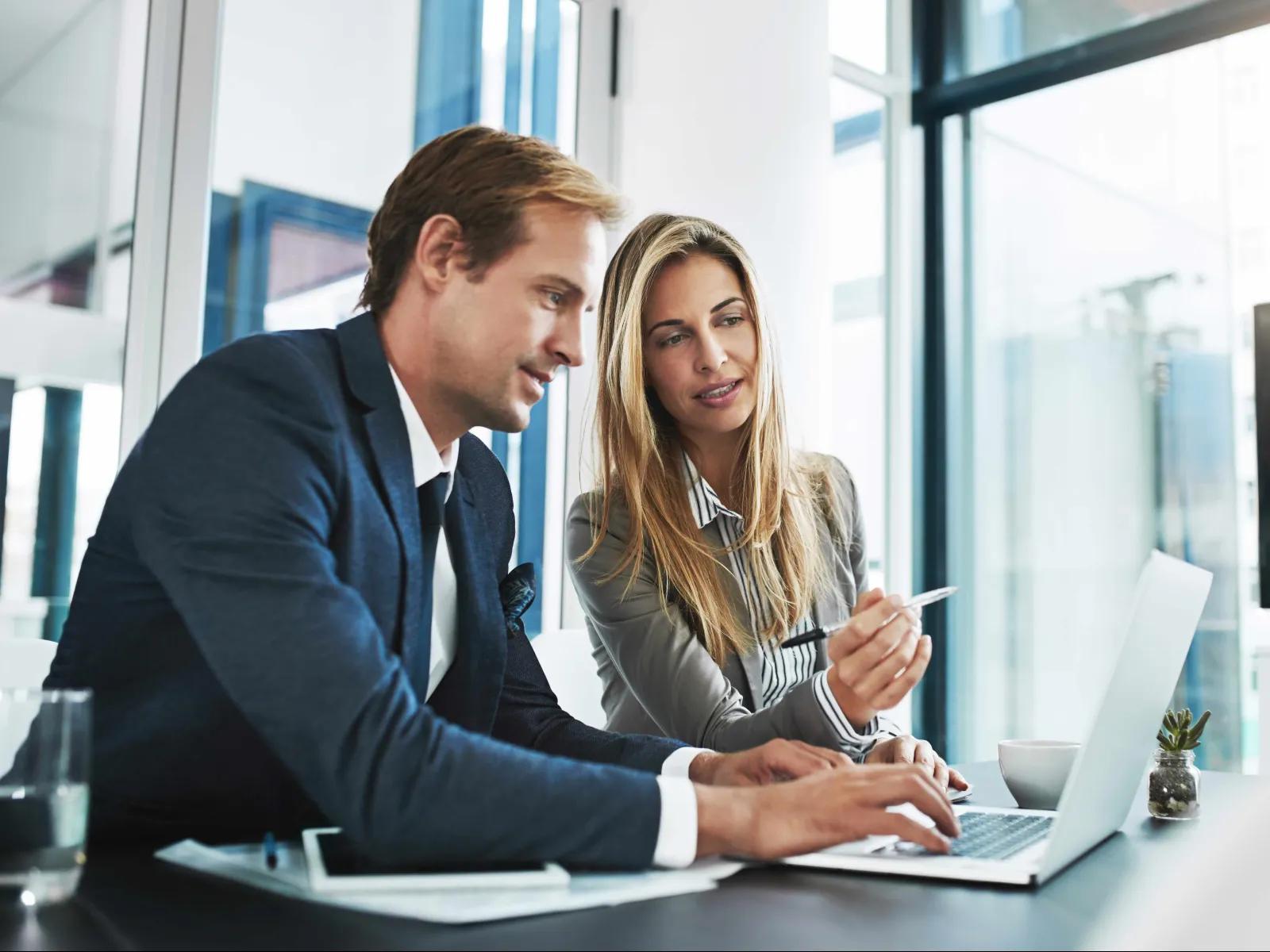 a man and a woman looking at a laptop