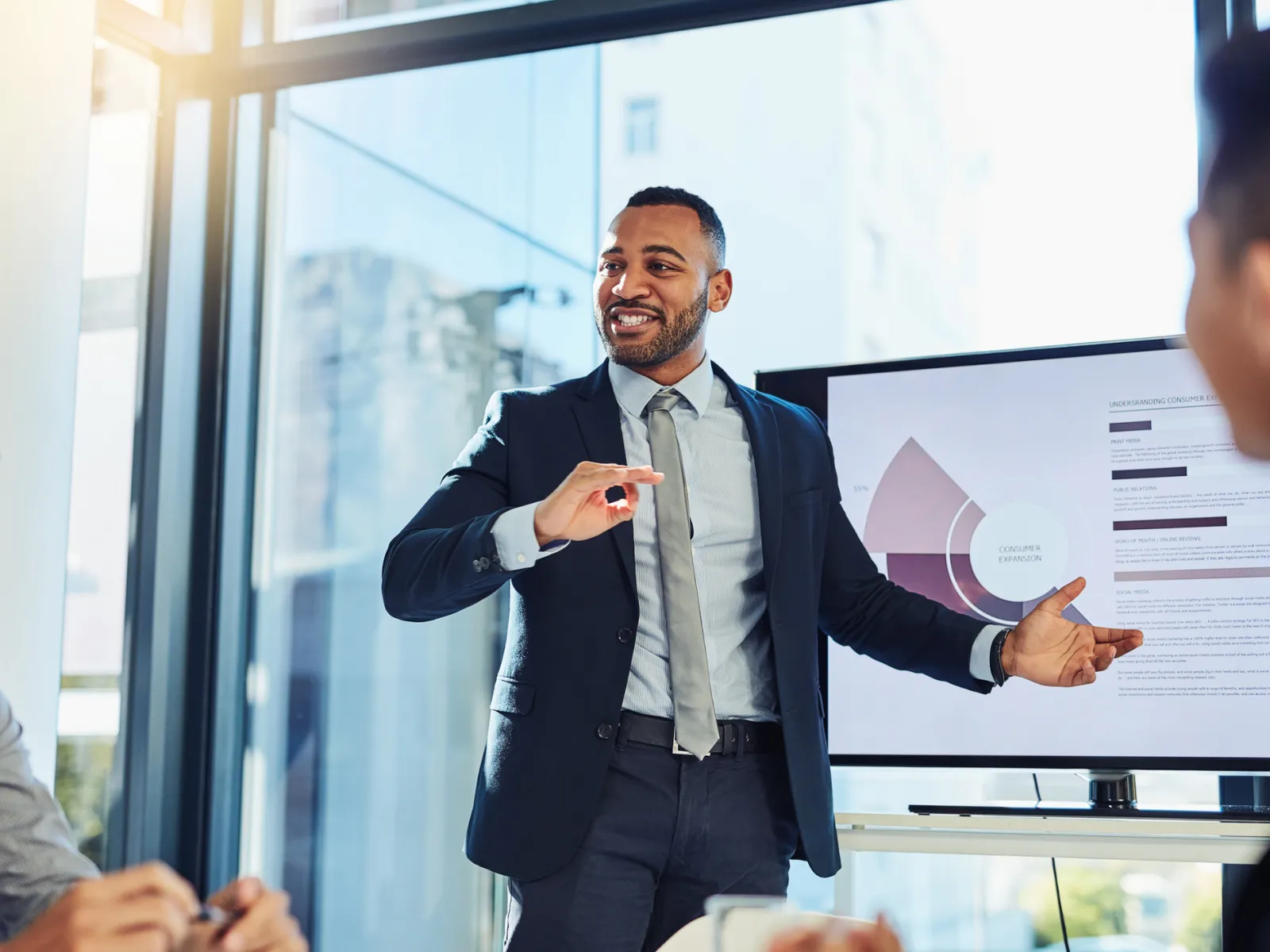 a person in a suit talking to a group of men