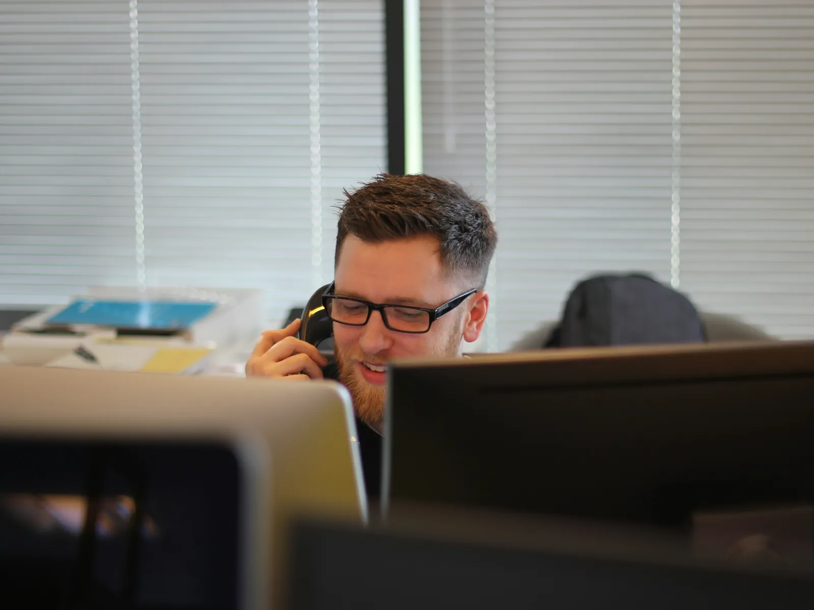 a man with a beard sitting at a desk with a computer