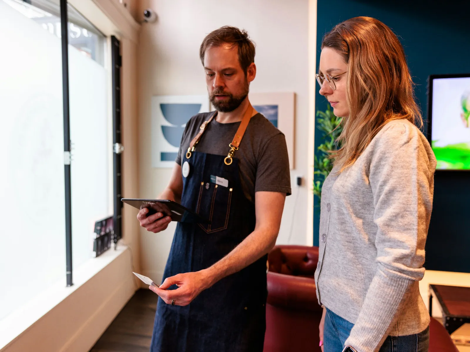 a man and a woman looking at a tablet