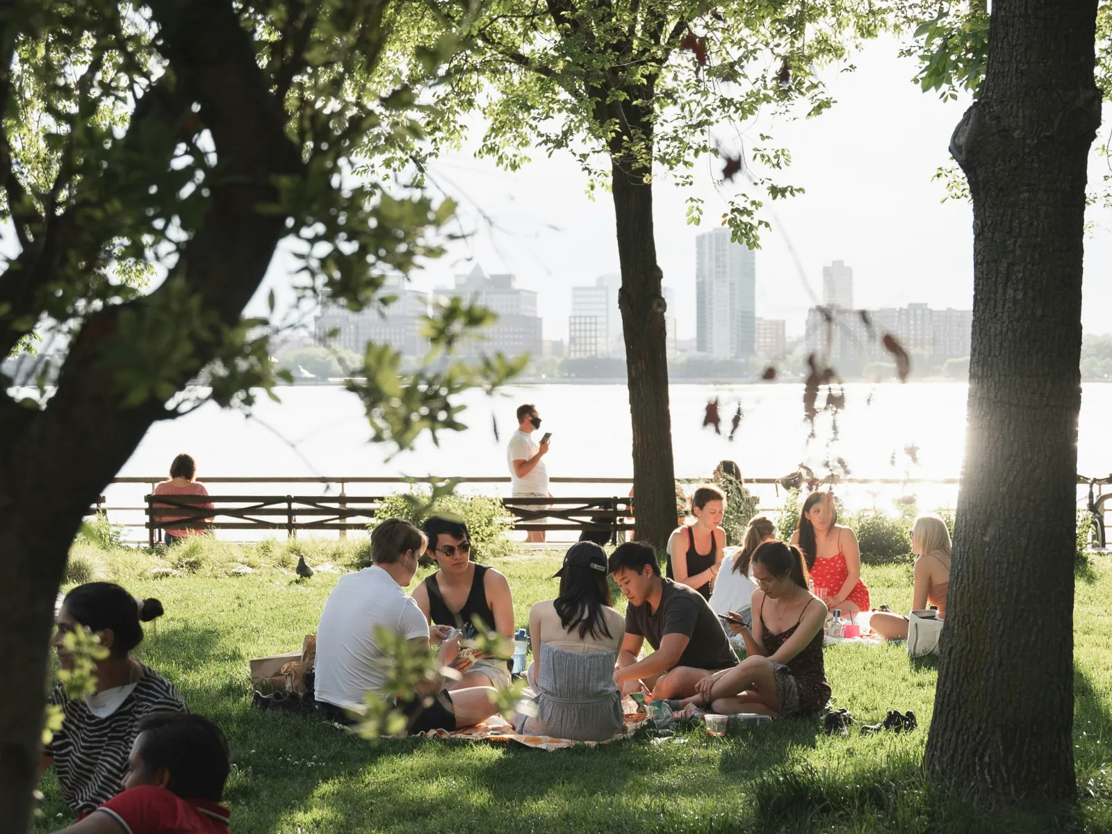 a group of people sitting at a picnic table in a park