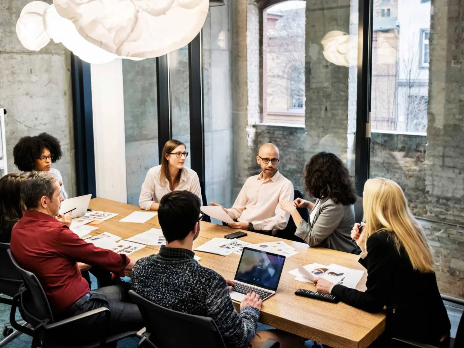a group of people sitting at a table in front of a laptop