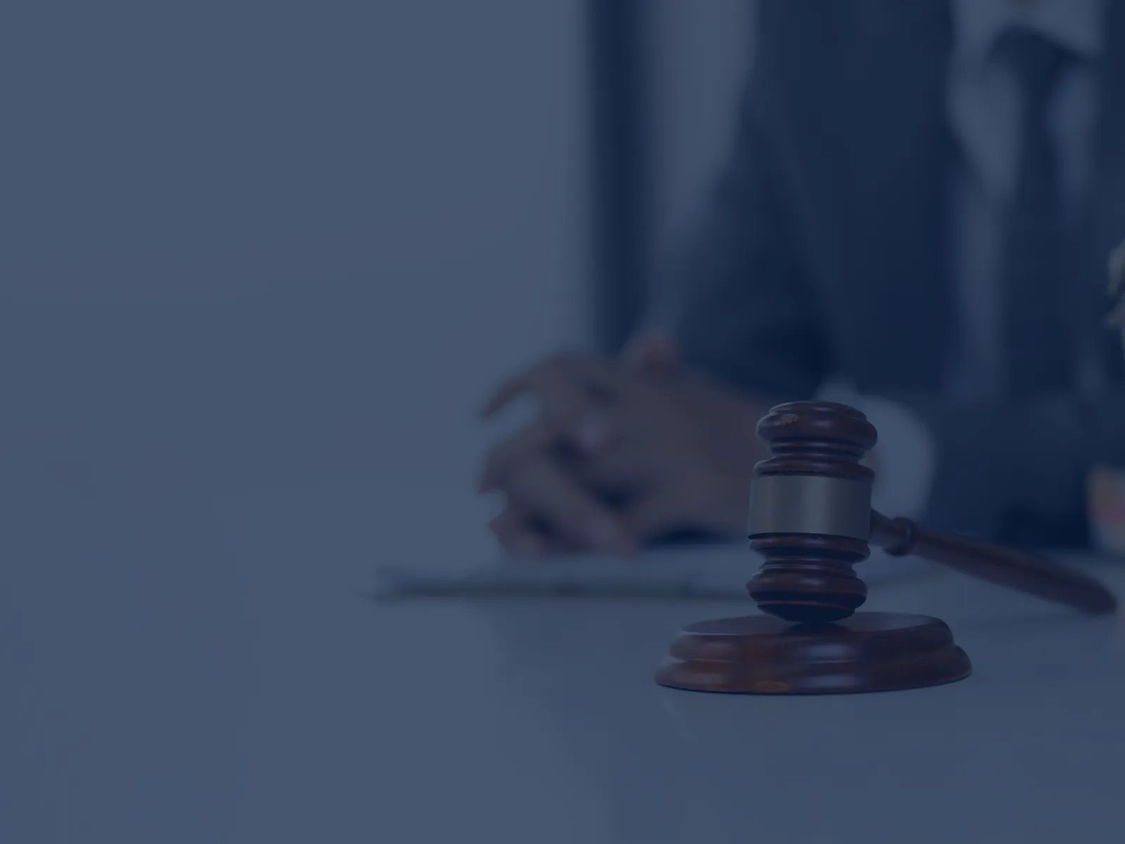 Close-up of a person’s hands gripping a car steering wheel while driving, dashboard and controls visible