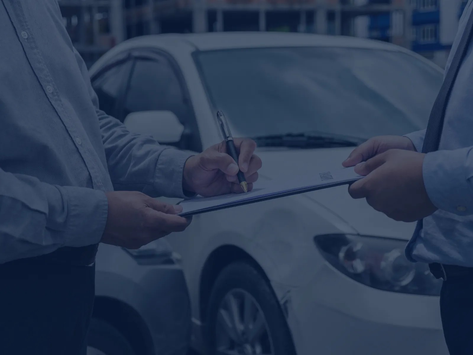 Two men inspecting a white car and signing documents, likely for car sale or insurance agreement.