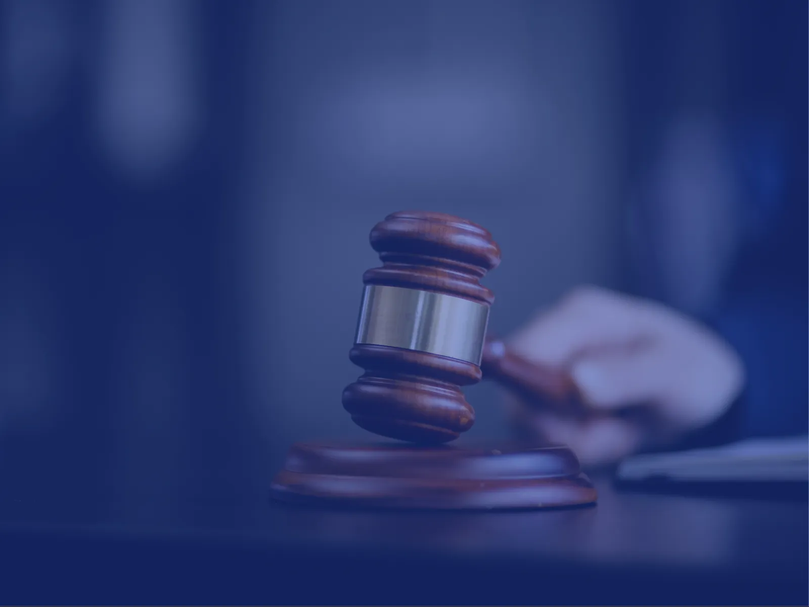 Close-up of a person’s hands gripping a car steering wheel while driving, dashboard and controls visible