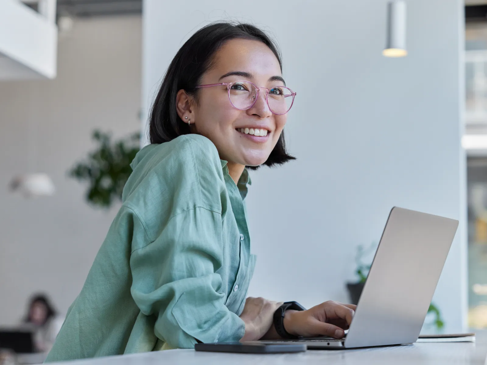a woman smiling while using a laptop