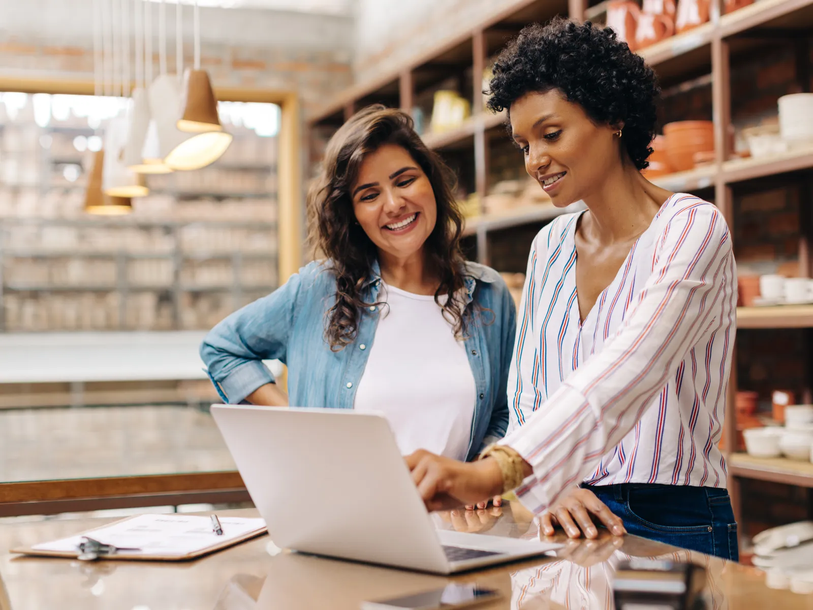 a couple of women looking at a laptop