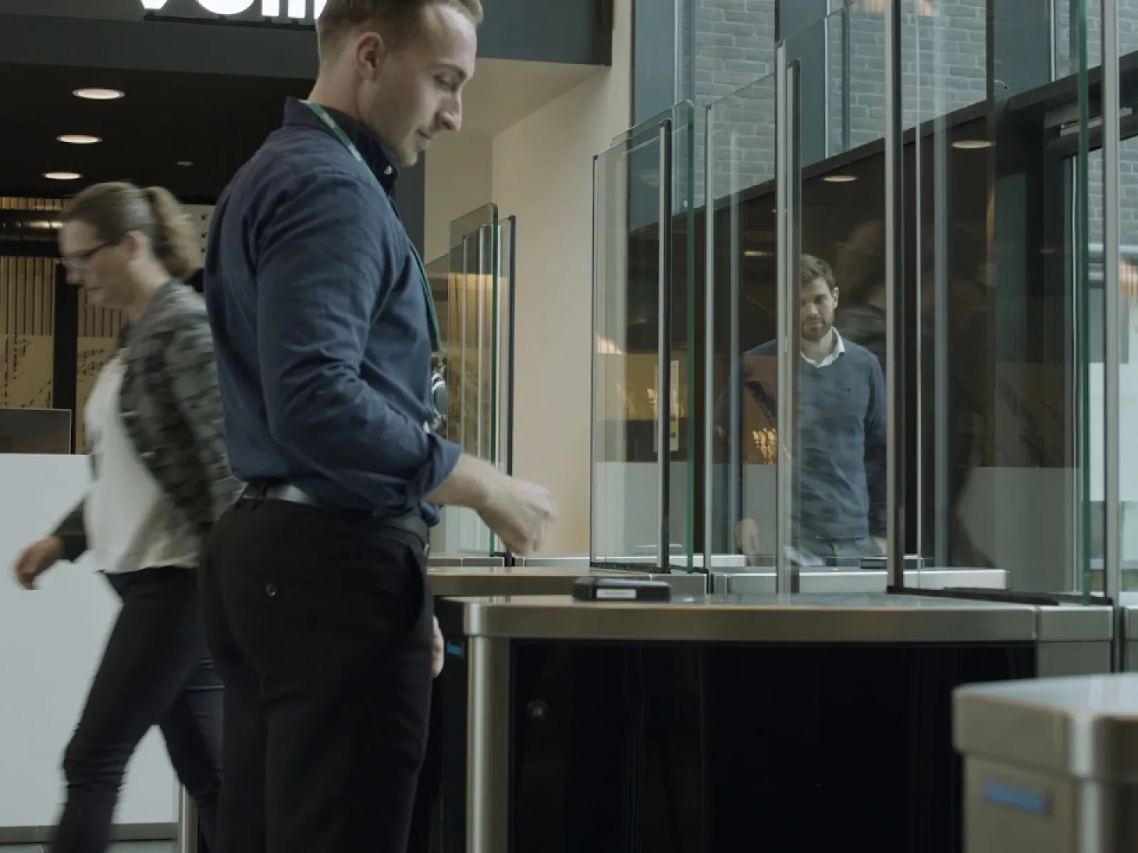 a man and a woman in front a turnstile security system