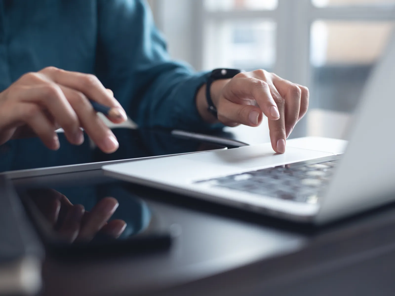 Person using laptop and holding credit card, making an online payment or shopping at home.