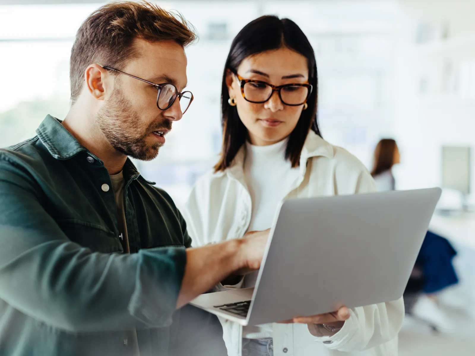 a man and a woman looking at a laptop
