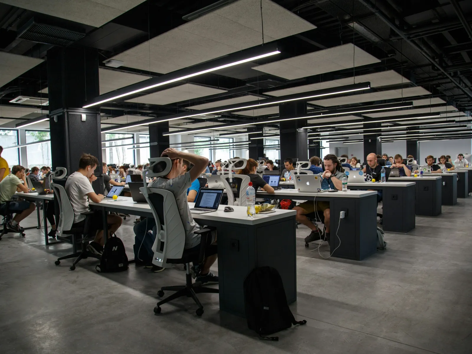 a group of people sitting at desks in a large room