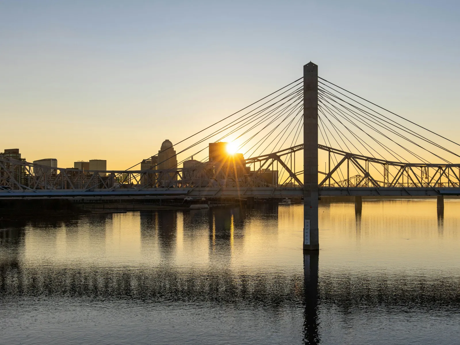 a bridge over water with a city in the background
