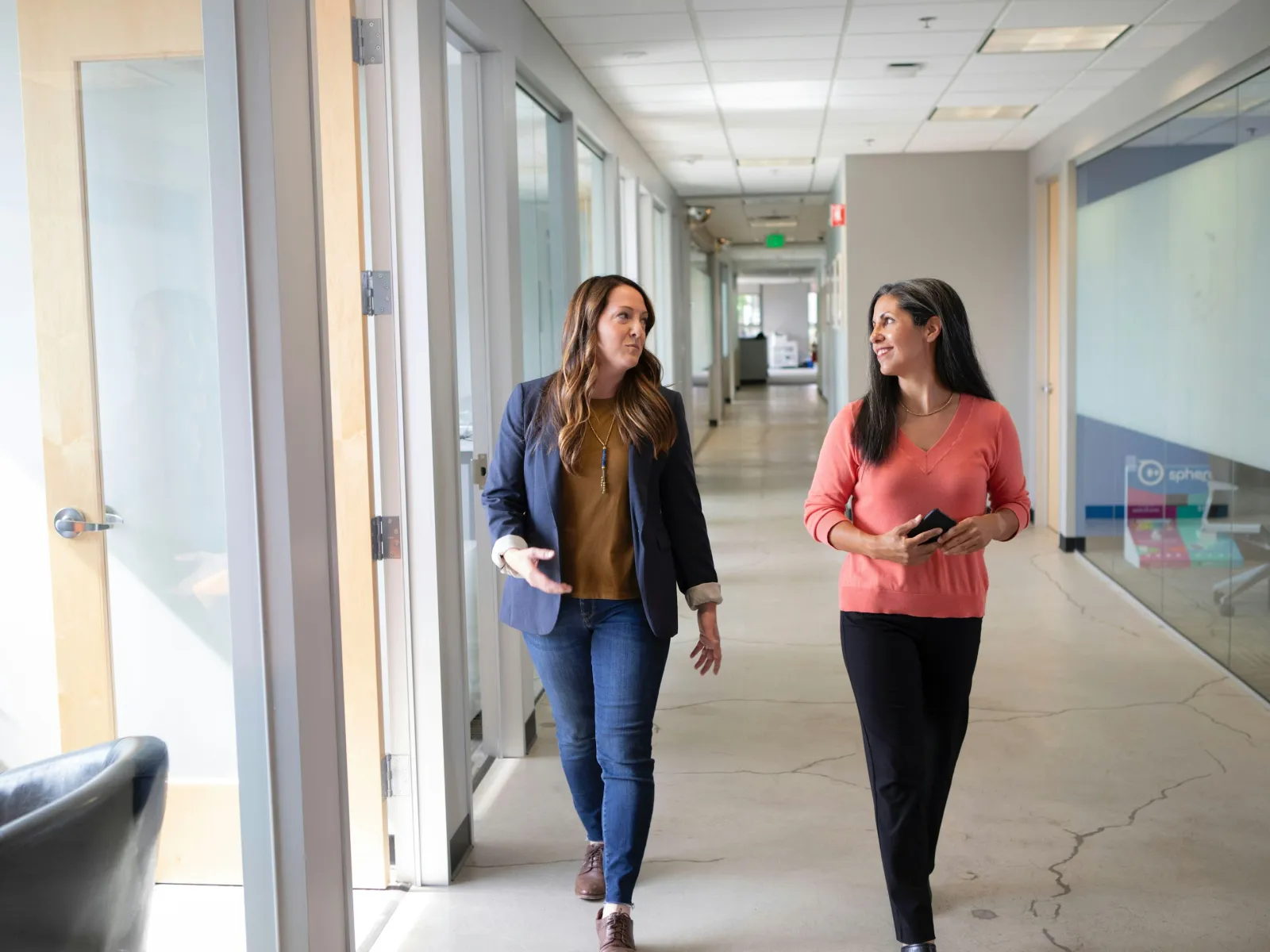 a couple of women walking in a hallway