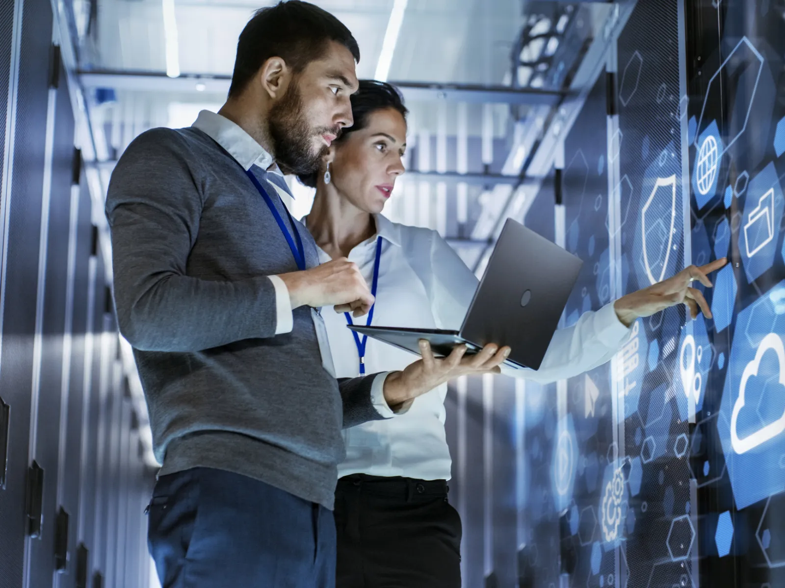 a man showing something on the laptop to a woman