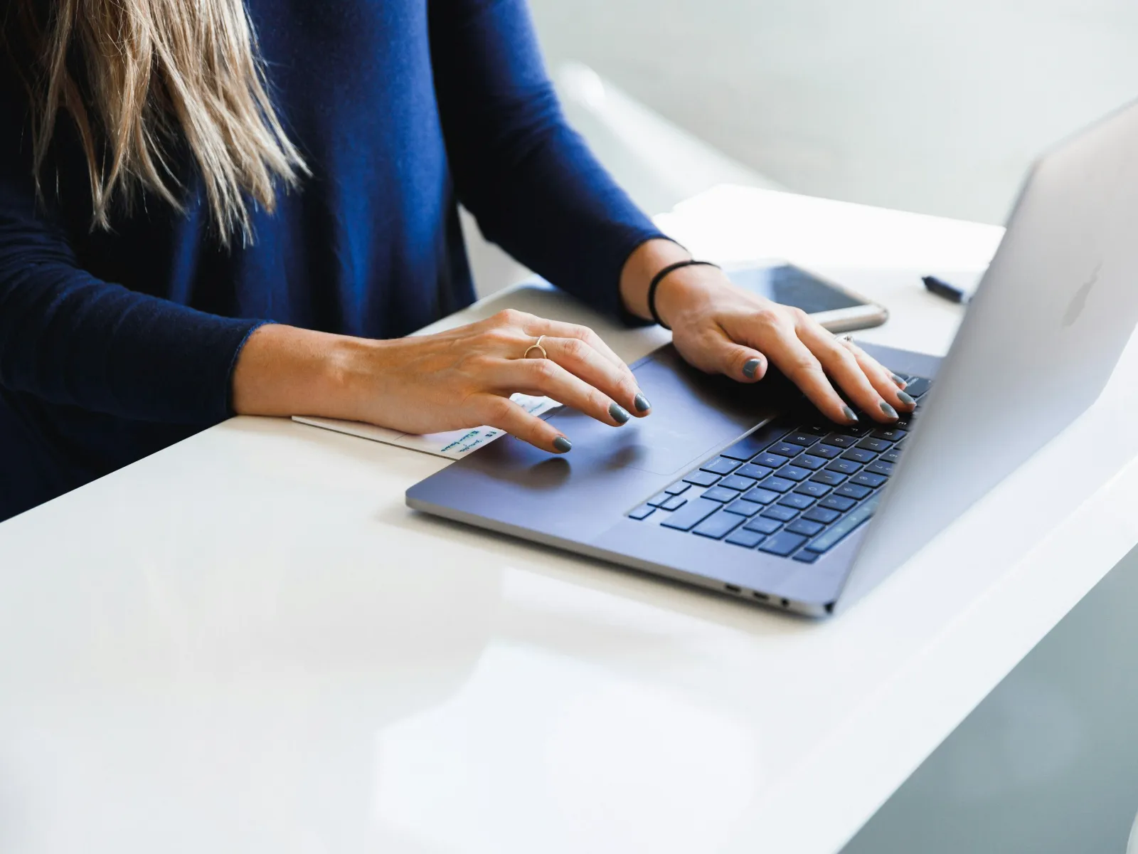 a woman typing on a laptop