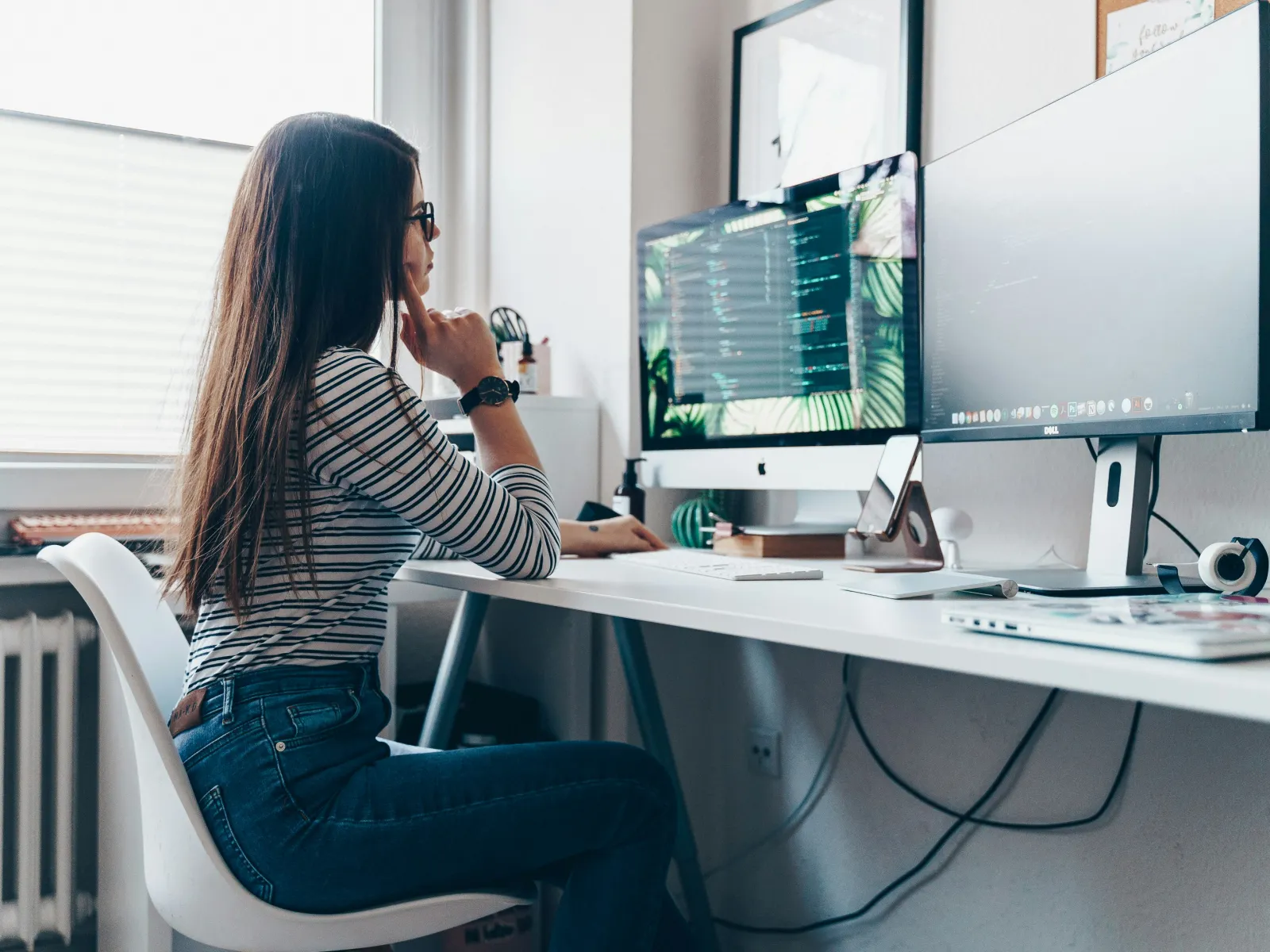 a woman sitting at a desk with a computer and a microphone