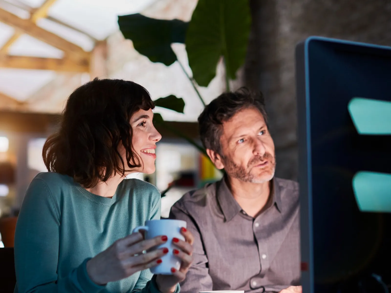 a man and a woman sitting at a table with a computer
