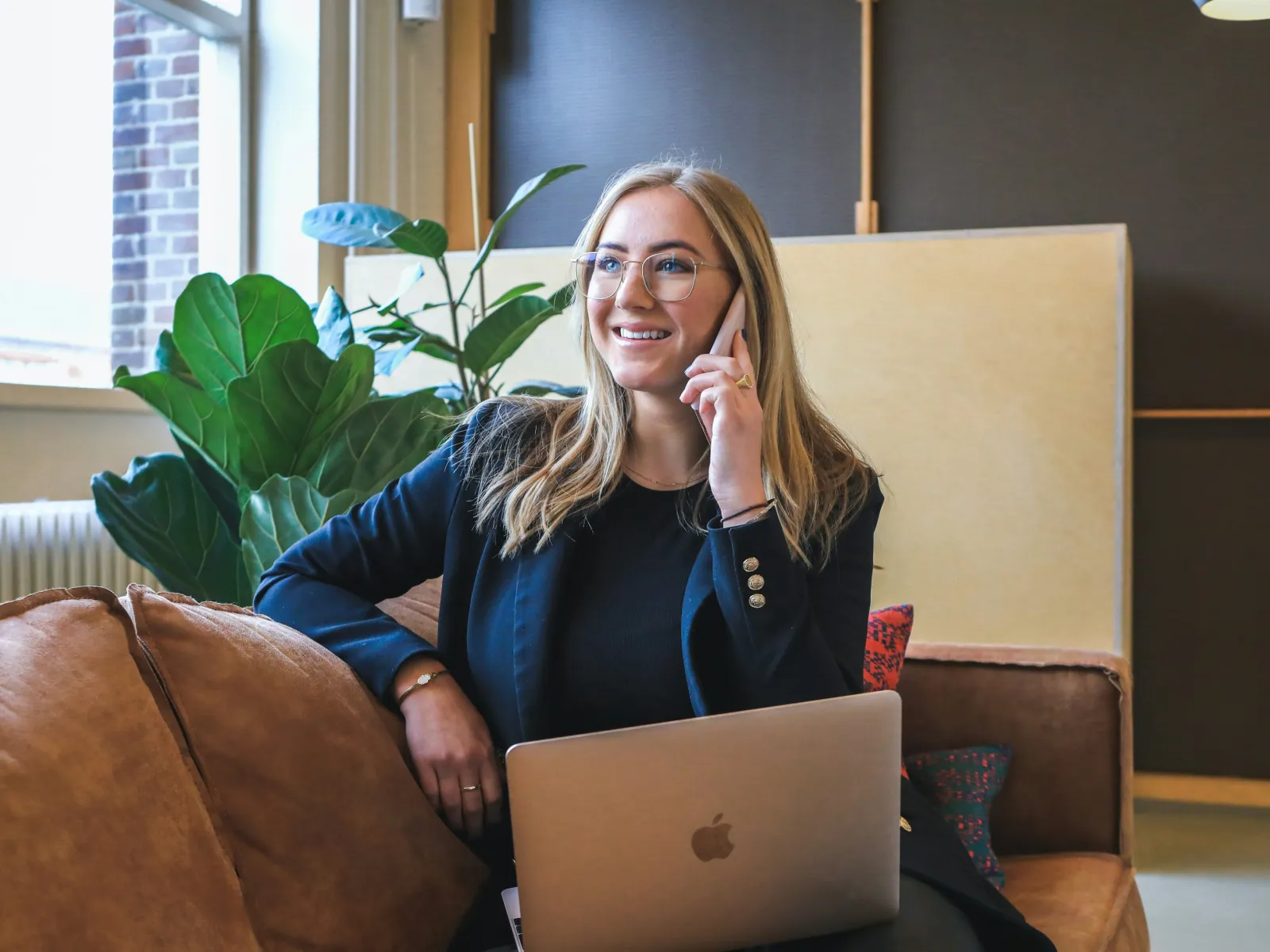 Kara Pacitto sitting on a couch with a laptop