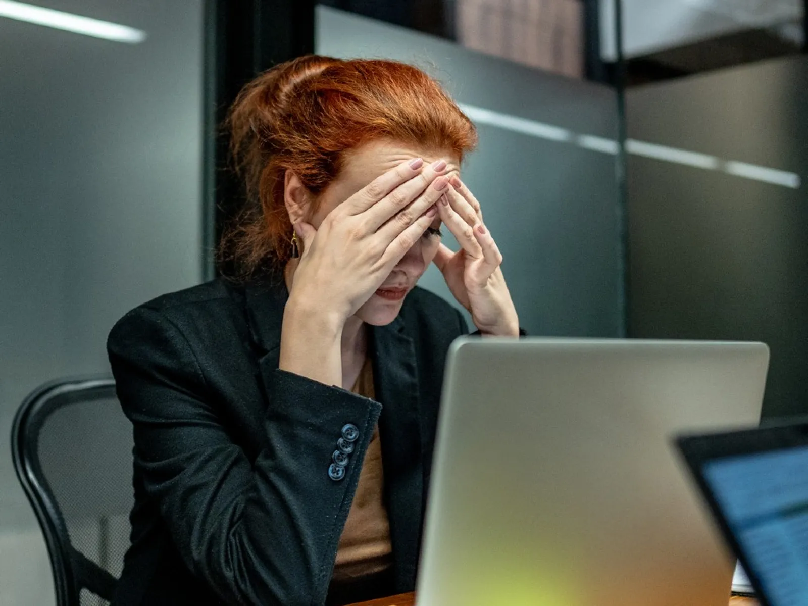 a person sitting at a desk with a laptop and a phone