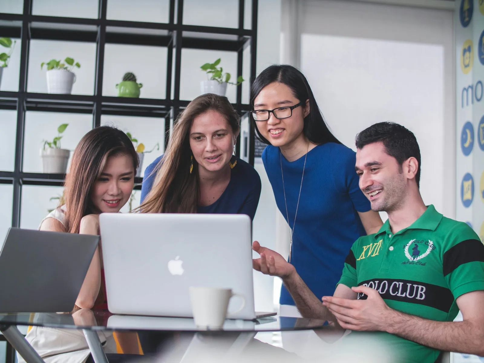 a group of people looking at a laptop