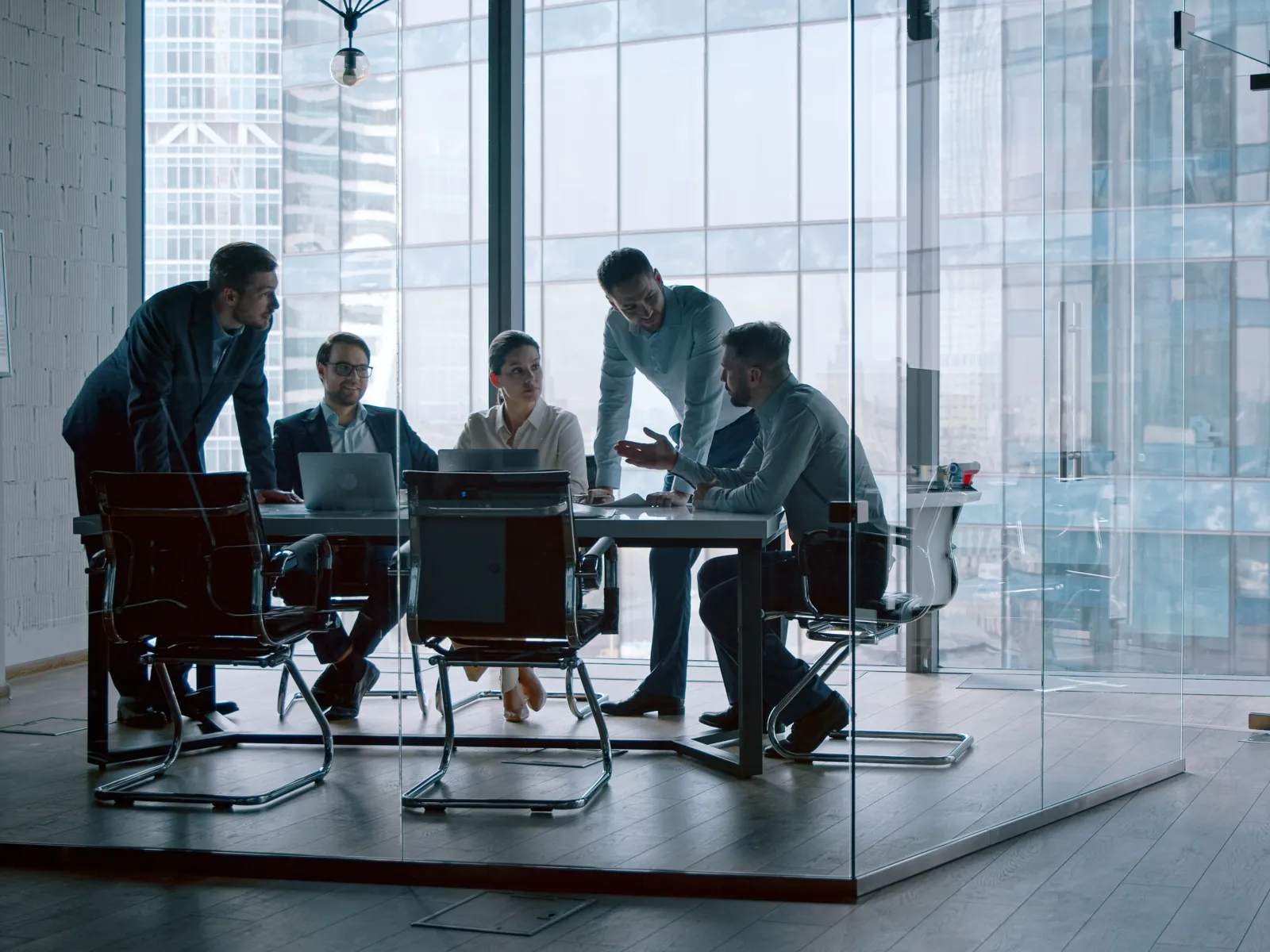 a group of people sitting at a table with laptops