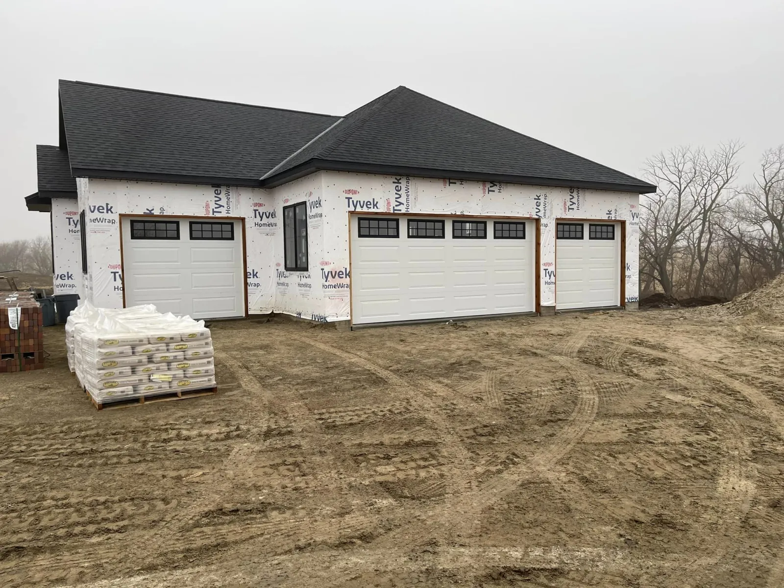 a house with garages and dirt