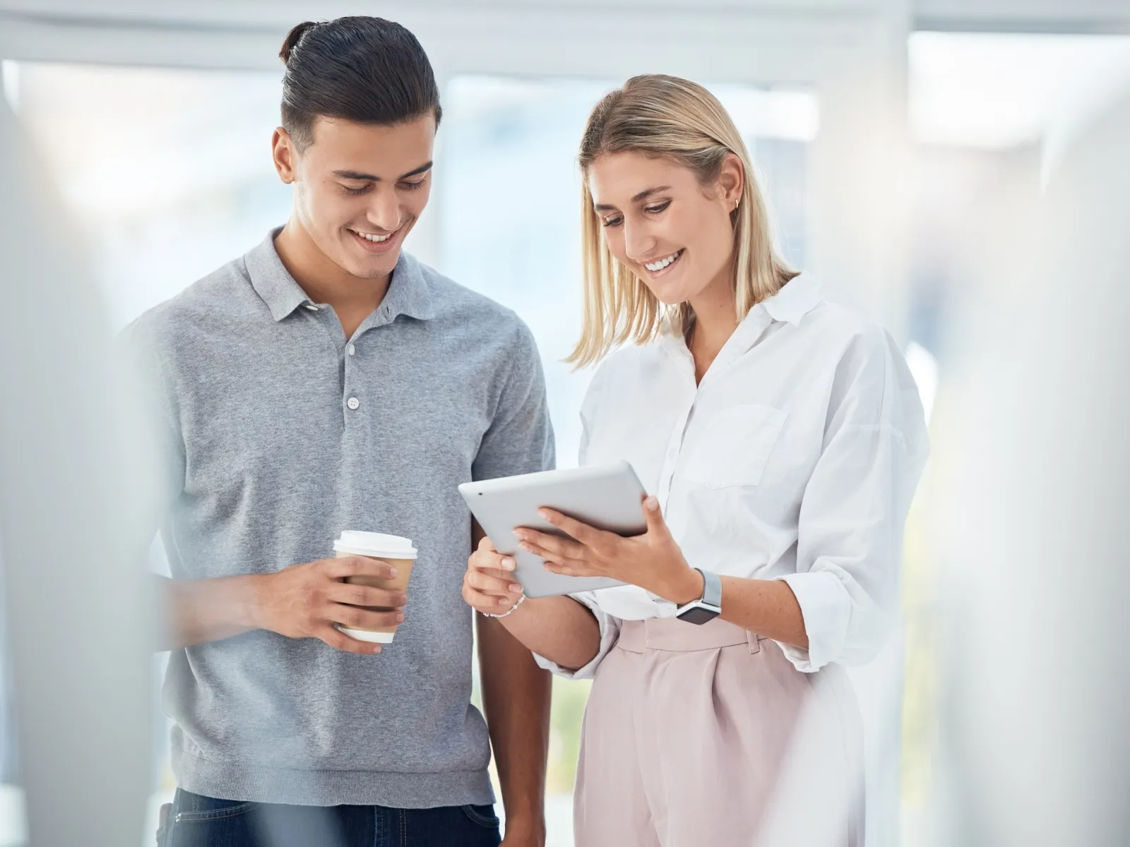 a man and a woman looking at a tablet