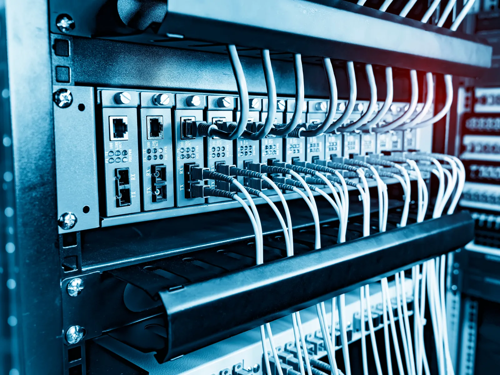 Close-up of network server rack with multiple Ethernet cables connected to switches in a data center.
