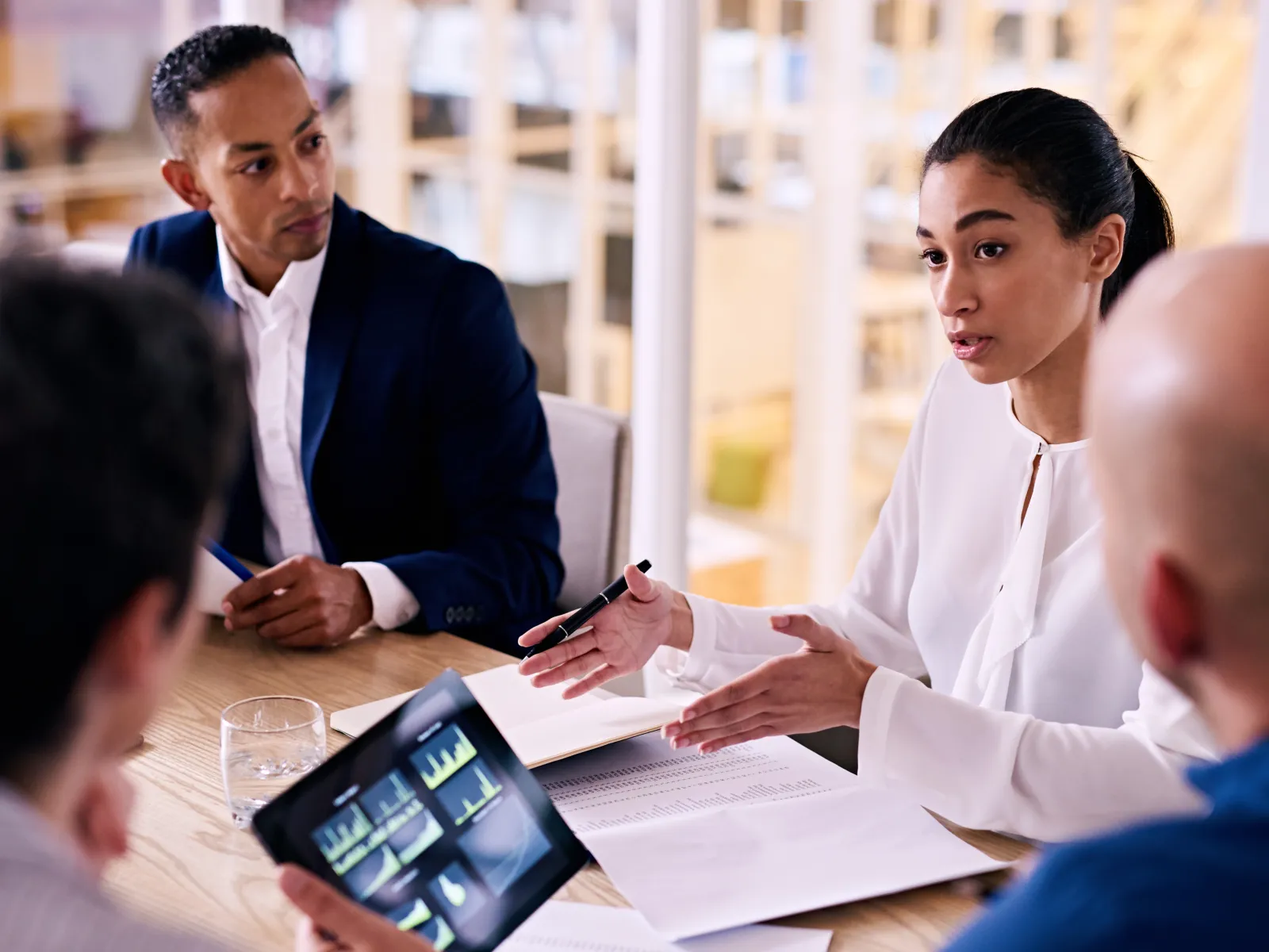 Business team discussing data charts and reports during a meeting in a modern office.