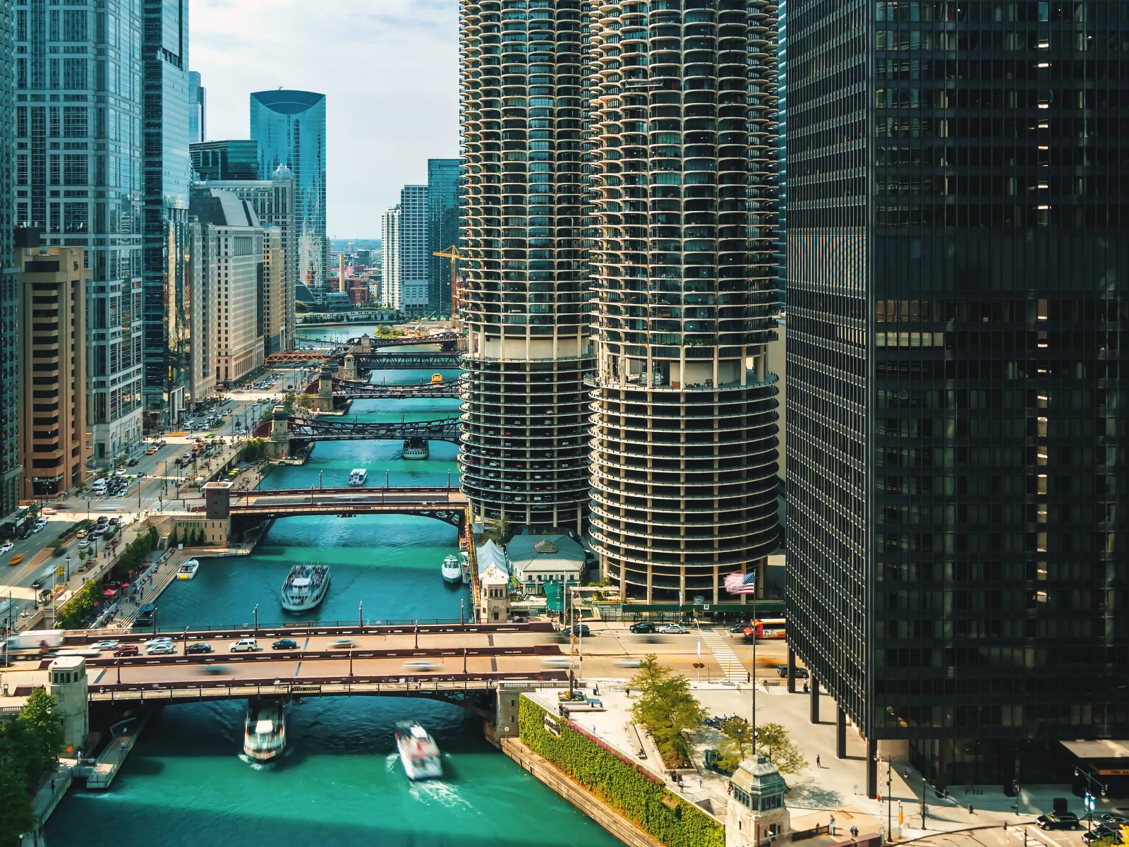Chicago River flowing through downtown with multiple bridges and high-rise buildings on both sides under a clear sky