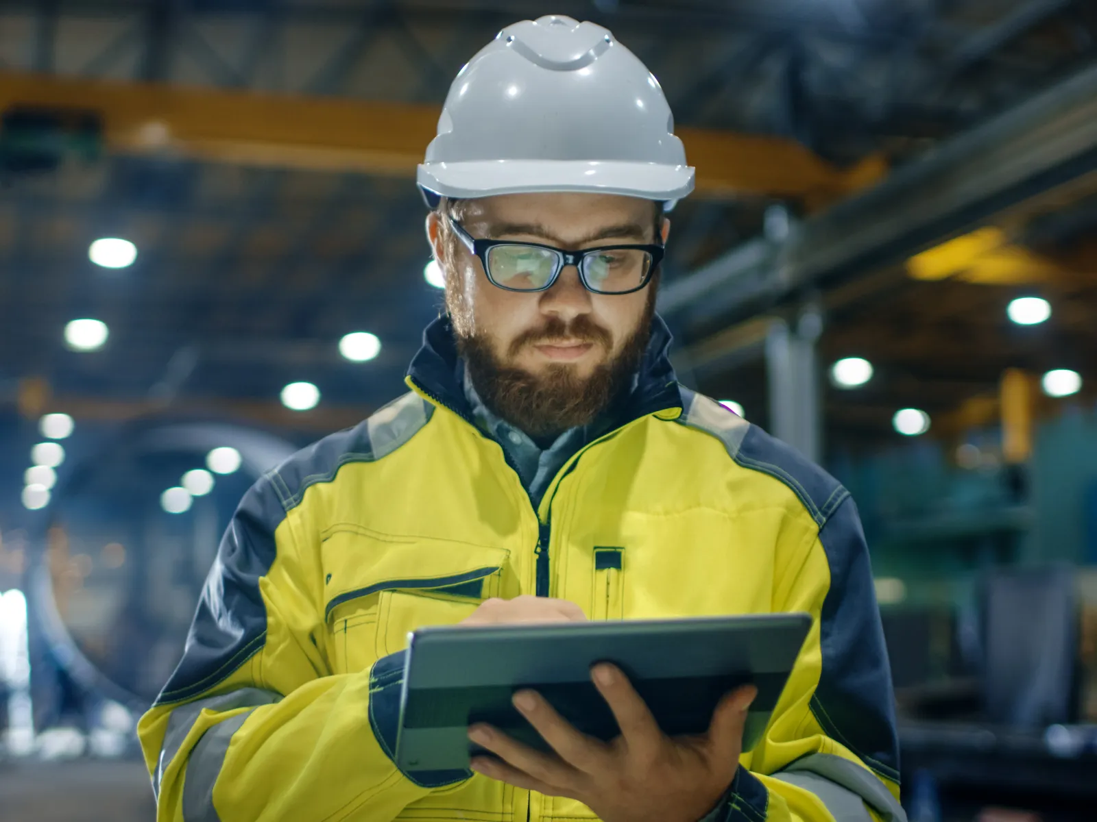 a man wearing a hard hat and safety goggles holding a tablet