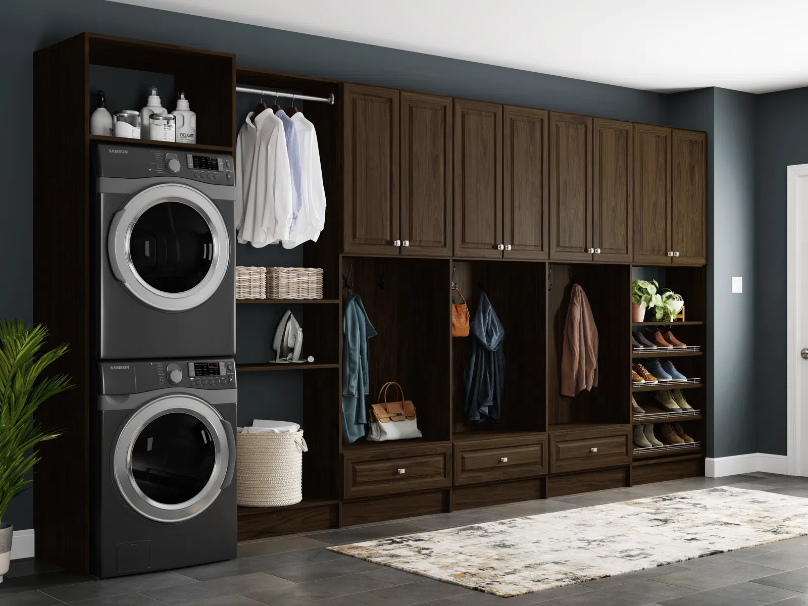 Mudroom with dark wood storage cabinets, stacked washer and dryer, hanging clothes, shoes, and a light gray rug on tile floor.
