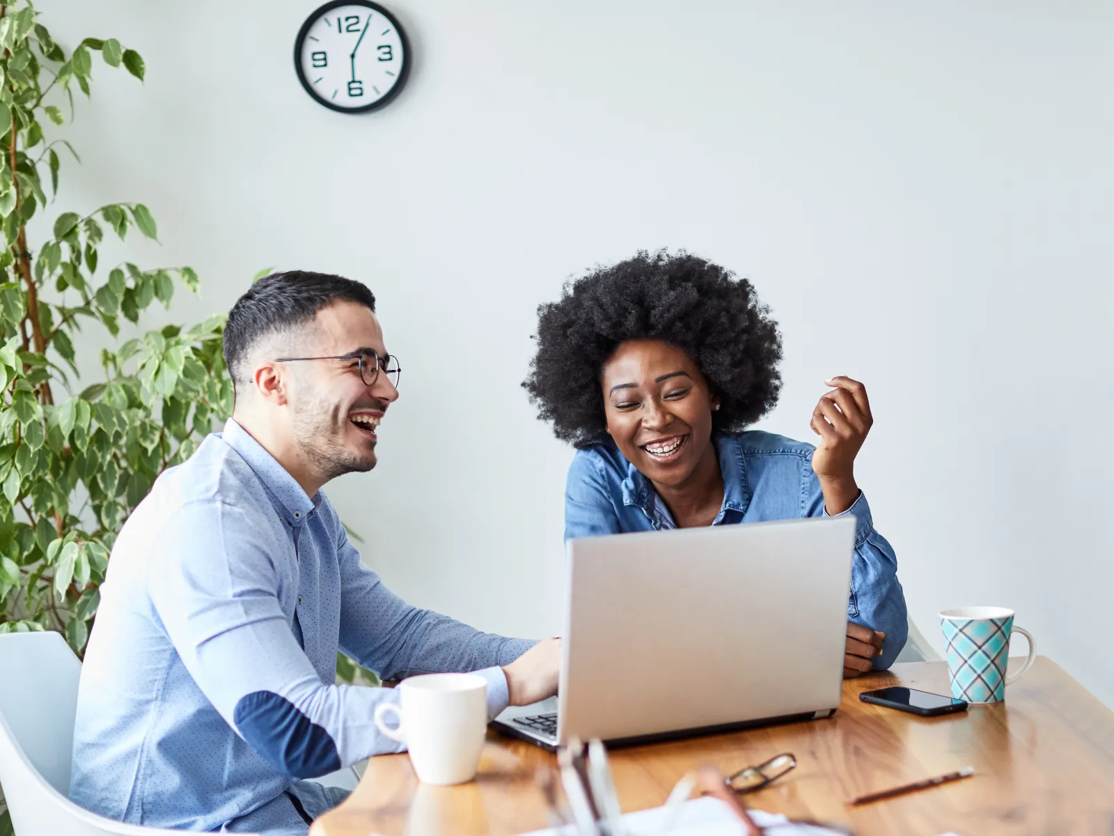 a man and a woman sitting at a table with a laptop