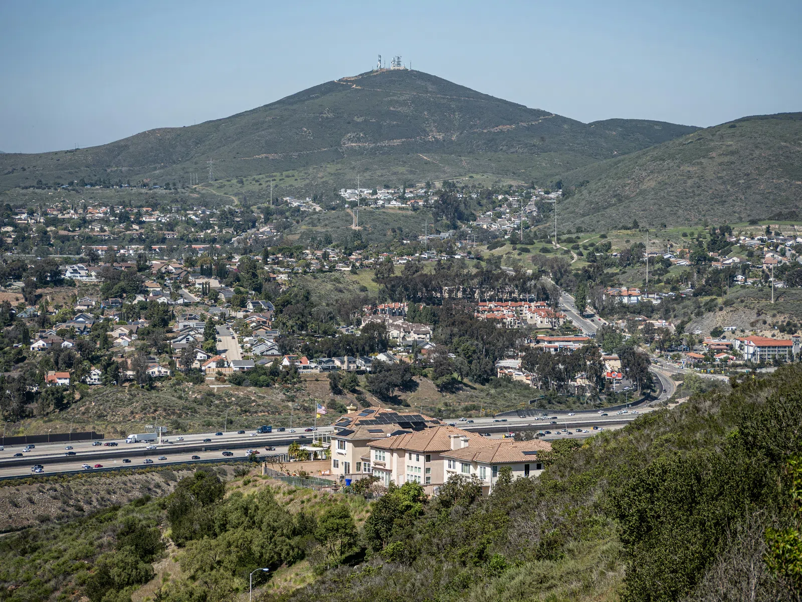 View of a suburban area with houses, highways, and a mountain in the background under a clear sky