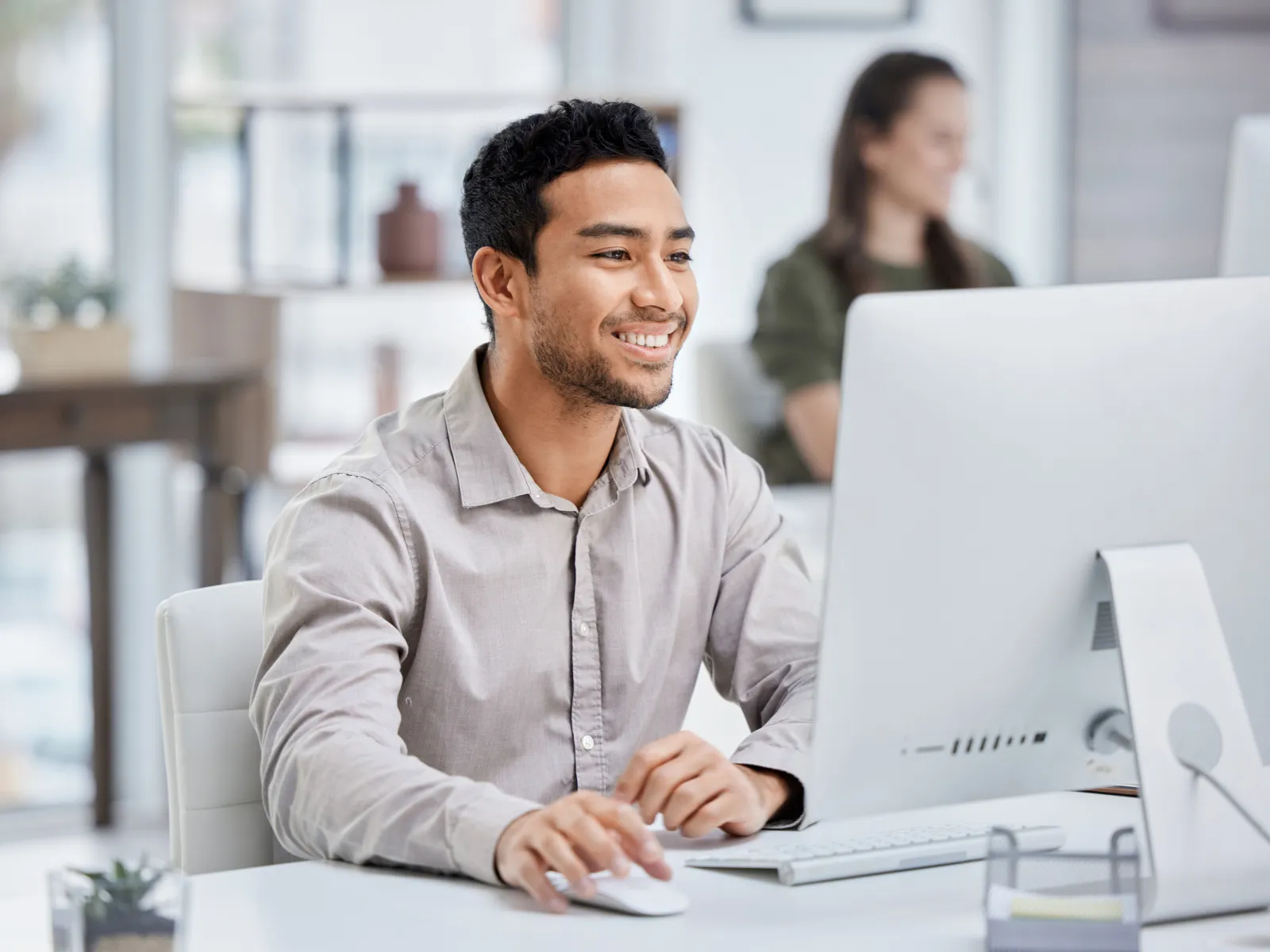 a man smiling while using a computer