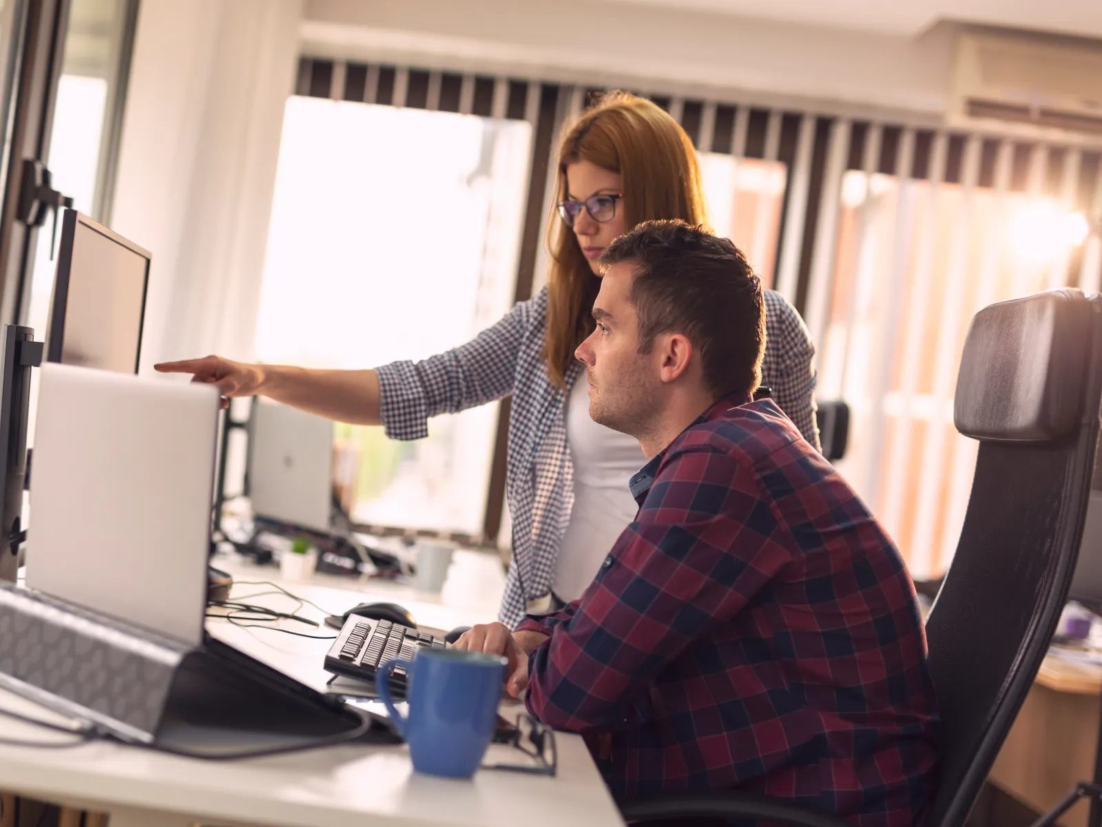 a man and a woman looking at a computer screen