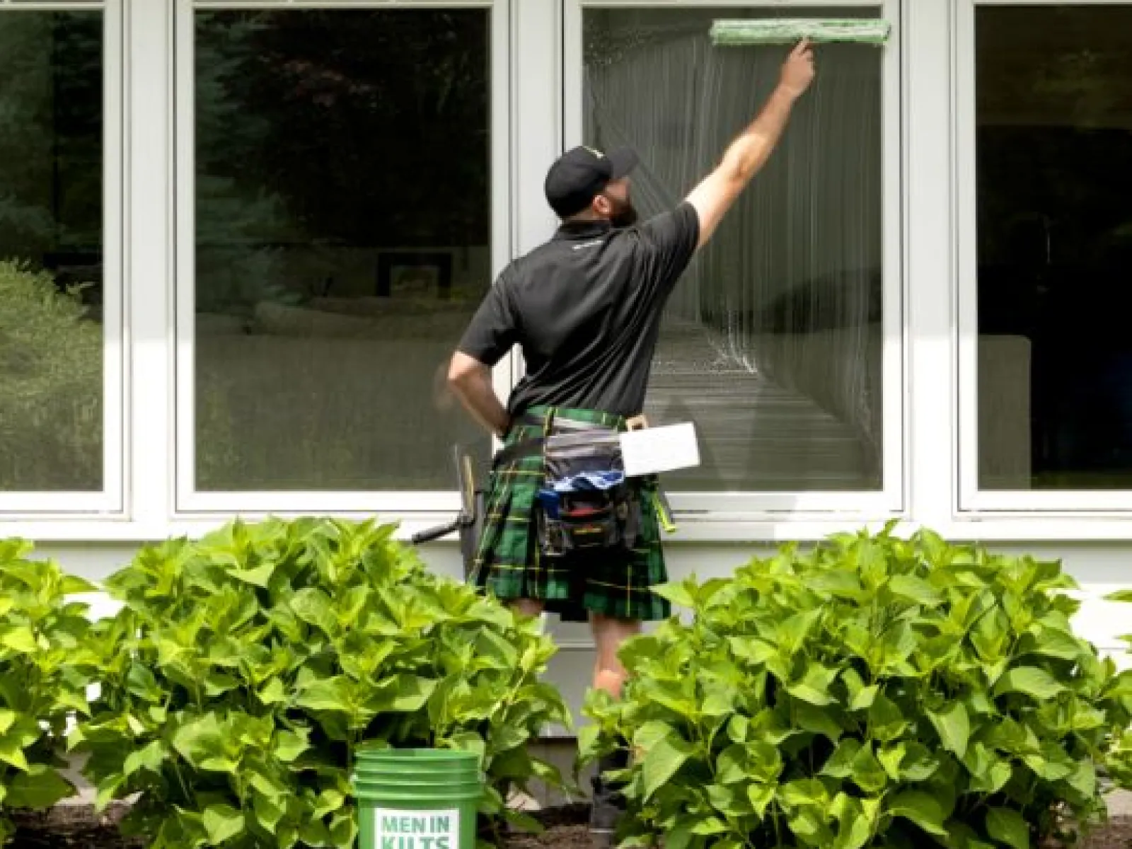 a man holding a newspaper and standing outside a building