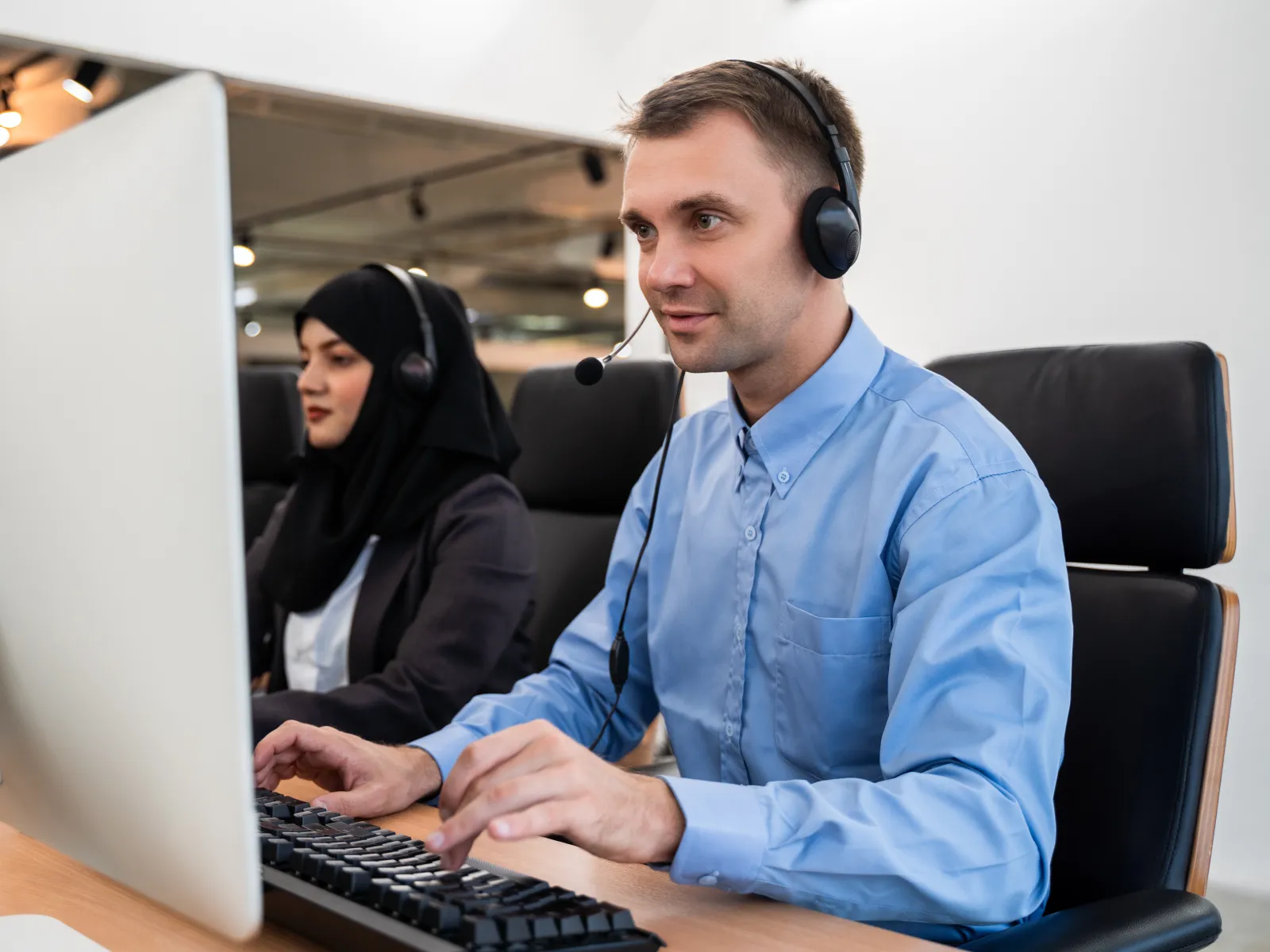 a person wearing headphones and sitting at a computer